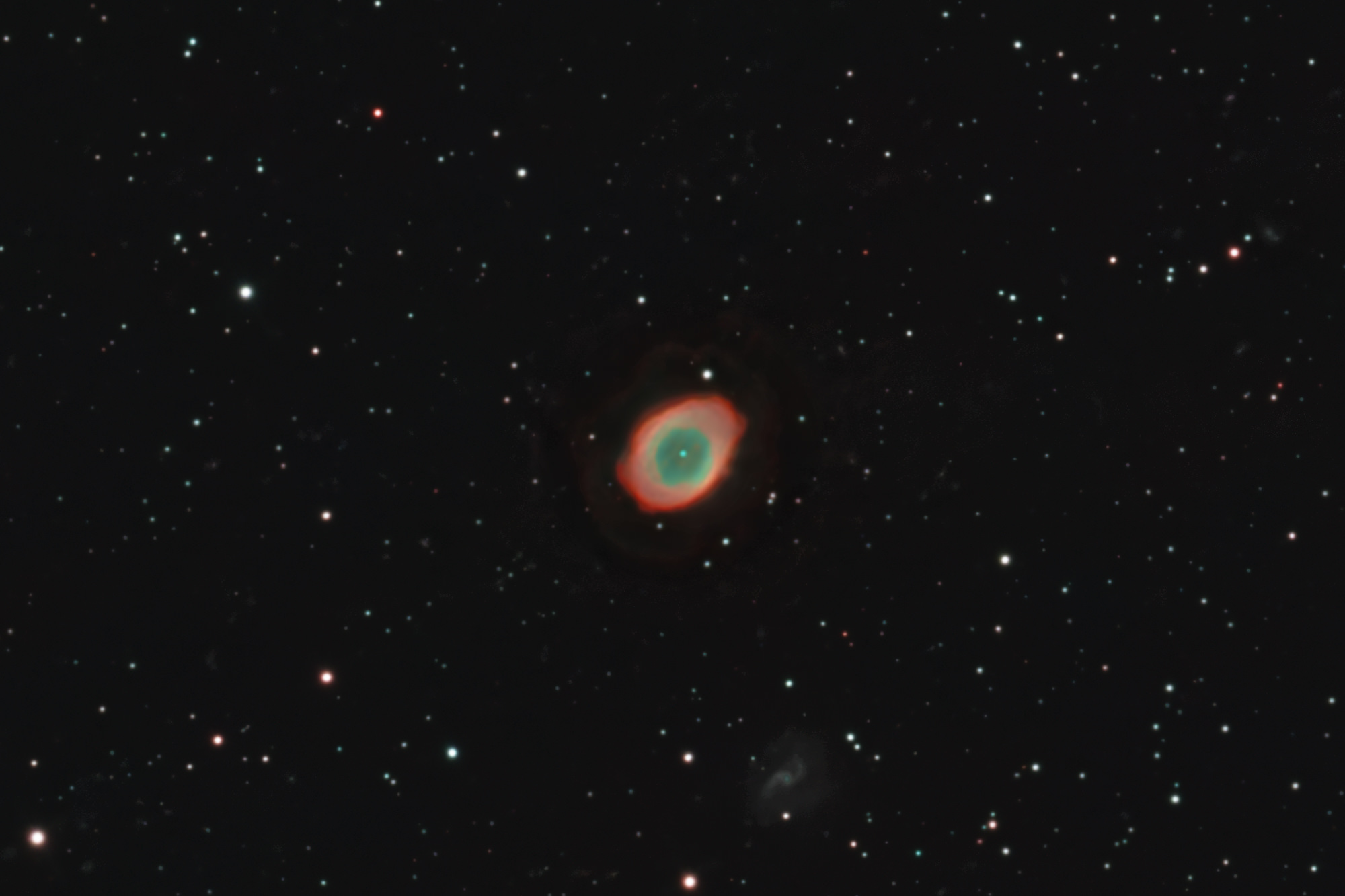 Der Ringnebel Messier 57 ist ein Planetarischer Nebel im Sternbild Leier.  Etwas unterhalb ist die Balkensoiralgalaxi IC 1296 zu erkennen.